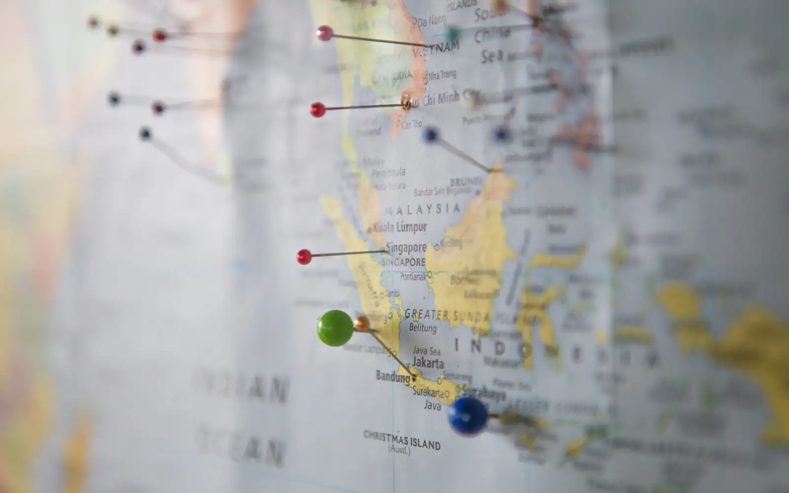 Close-up of a wall map with coloured pins marking Indonesia, Malaysia and Singapore